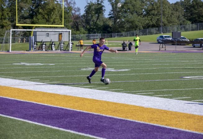 a Bethel athlete player dribbles the soccer ball during a match