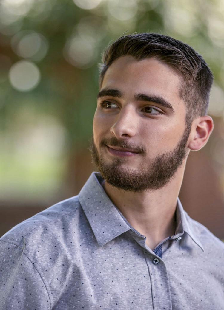 a male student looks of camera during an outdoor portrait