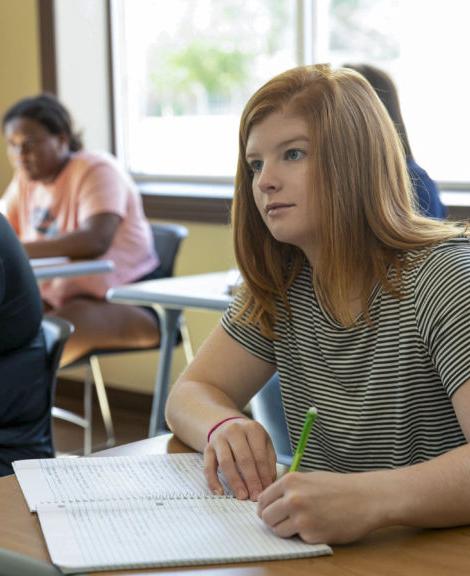 a female student listens and takes notes during class