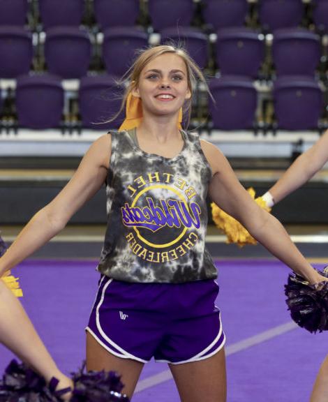 a cheerleader smiles during cheer practice