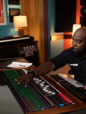 A sound engineer using the mixer in a recording studio